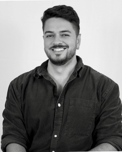 Gus Dantas, smiling, in a dark corduroy shirt